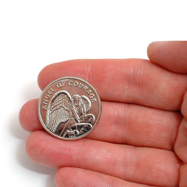 Silver 'Angel of Courage' coin held in a hand on a white background