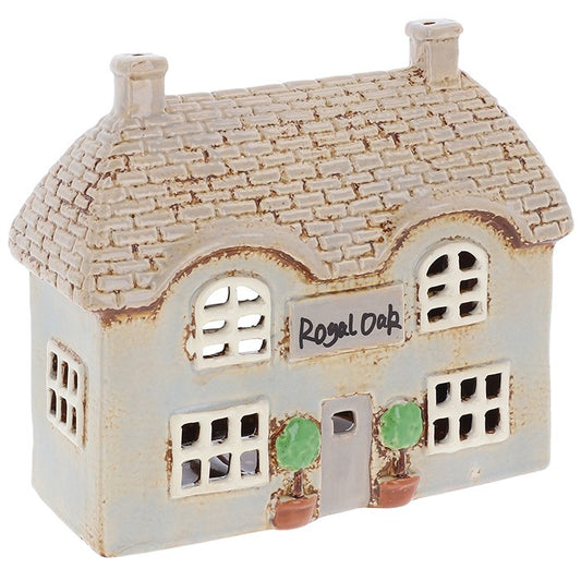 Handcrafted in the Village Pottery workshop, the Royal Oak Pub tealight holder is a charming ceramic piece inspired by traditional village life. With intricate detailing and rustic features, it captures the warmth and character of a classic village pub. Measuring 15.5 x 17.8 x 8cm, it glows beautifully when a tealight candle is placed inside, creating a cosy and inviting atmosphere. Perfect for mantelpieces, shelves, or as part of a village display, this ceramic tealight holder is a timeless keepsake that b