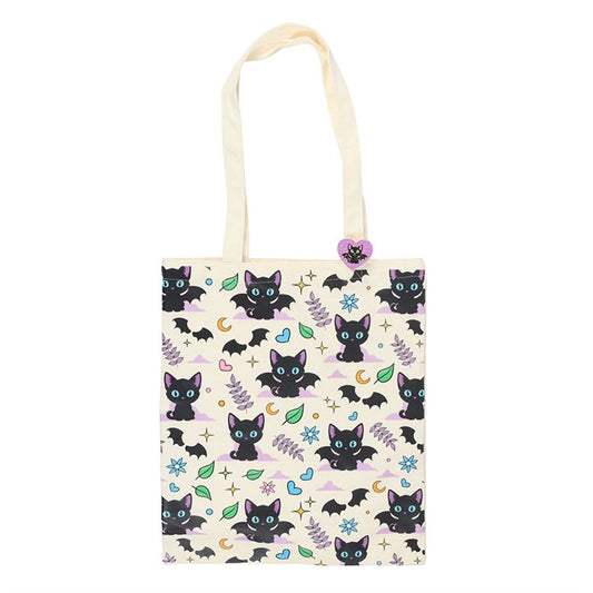 Carry your essentials in spooky style with this polycotton tote bag featuring an all-over print of playful black cats, bat wings, stars, and moons. Includes a coordinating enamel pin, making it an ideal gift for gothic and feline lovers alike.