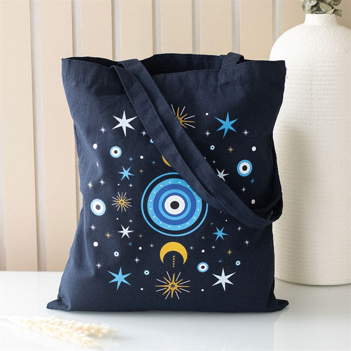 Black tote bag with celestial design on a white surface