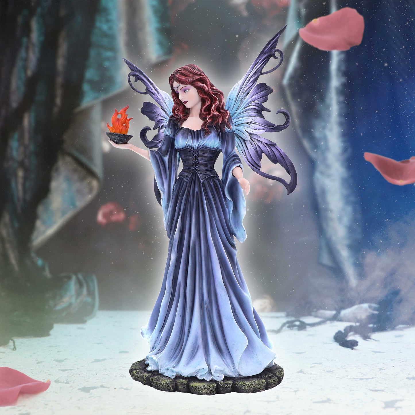 Fairy figurine with purple wings and a blue dress holding a lantern in a fantasy setting.