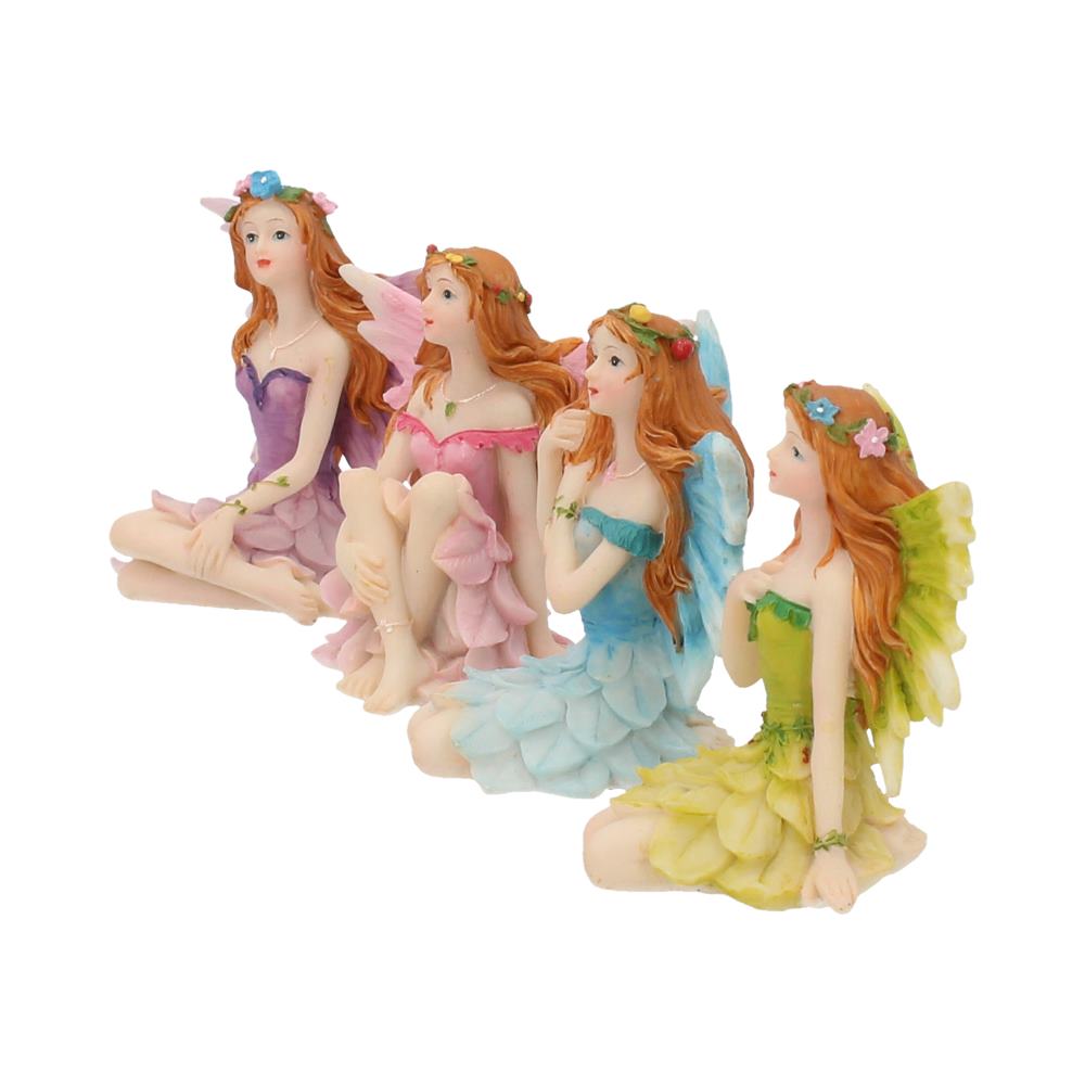 Four fairy figurines in colorful dresses on a white background