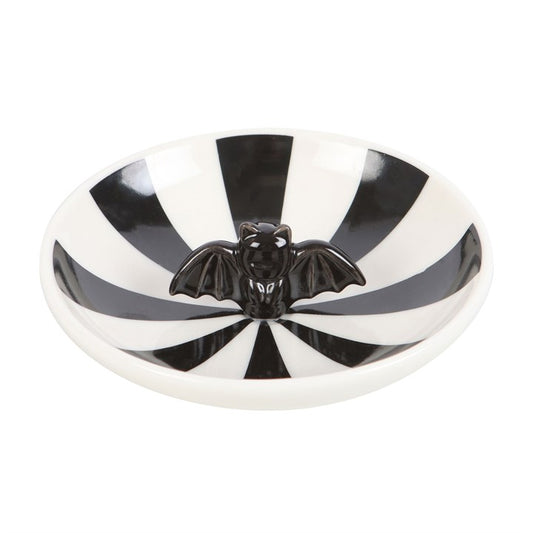 This enchanting trinket dish showcases a mesmerizing black and white striped pattern surrounding a mysterious black bat at its heart. Ideal for those drawn to daring, distinctive decor, it offers a magical way to store your jewellery, keys, or treasured little charms.