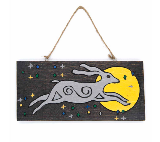 Hares have long held sacred significance in ancient spiritual traditions worldwide. In pagan lore, spotting a hare gazing at the moon symbolizes growth, renewal, fresh starts, and blessings. This enchanting wall plaque, hand-painted and Fairtrade from Indonesia, features sturdy twine for effortless hanging indoors or outdoors. Measuring approximately 30cm by 14cm, it’s a mystical charm to invite positive energy into your space.