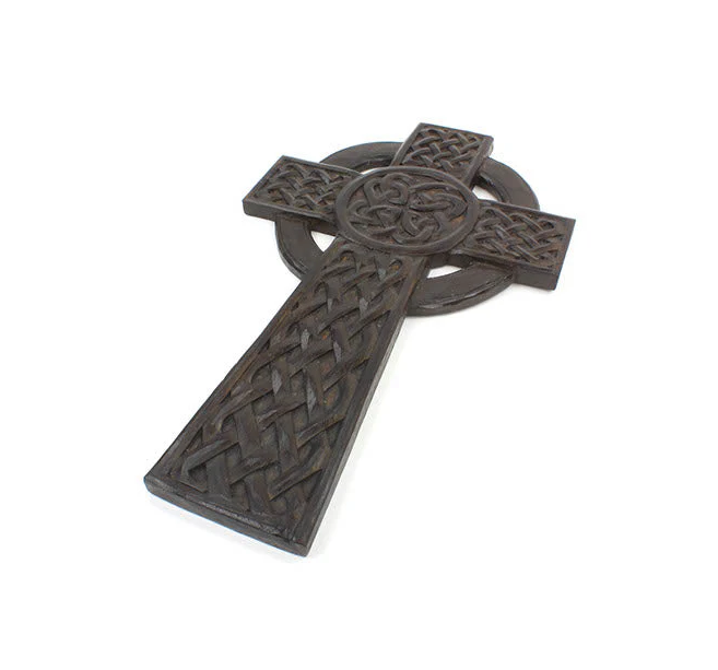 Decorative metal cross with intricate patterns on a white background