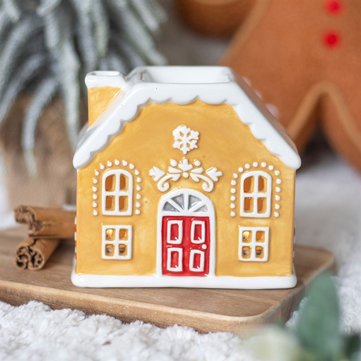 Decorative gingerbread house on a wooden board with a blurred background
