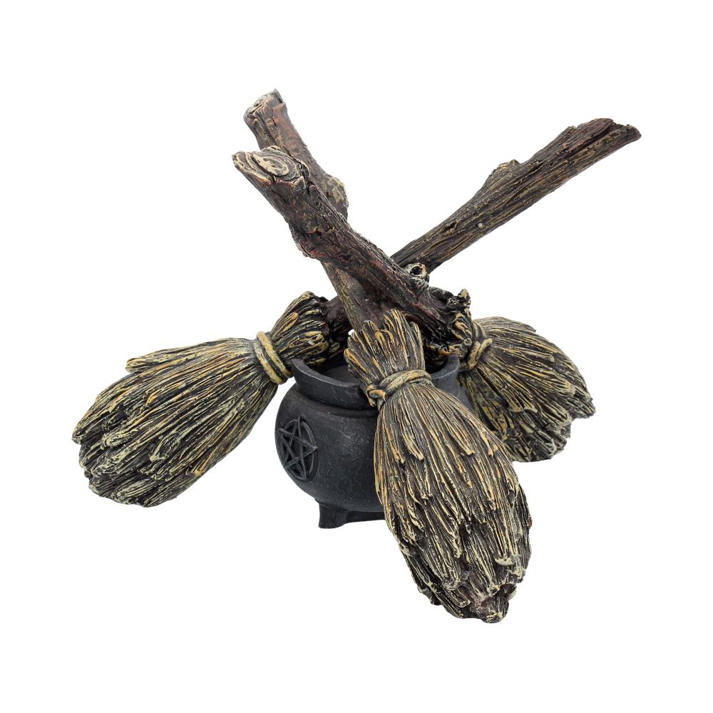 Decorative item with two brooms crossed over a black cauldron on a white background