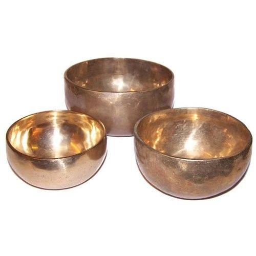 Three brass bowls of different sizes on a white background