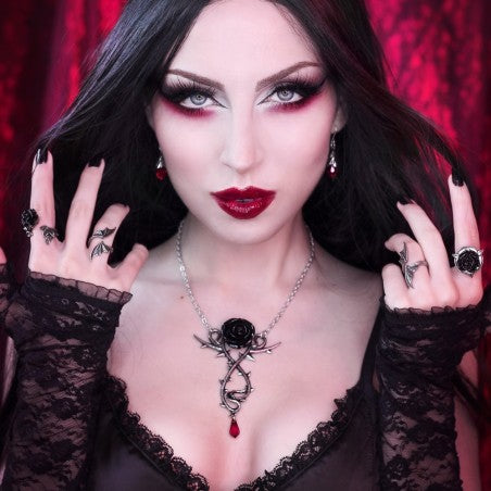 This Carpathian Rose Pendant Necklace is a stunning Gothic piece. This pewter necklace features a black rose mounted on a writhing thorned stem, featuring the most beautiful blood red, Austrian crystal dropper that appears as if a thorn has pierced the skin. A drama to your darkest attire!