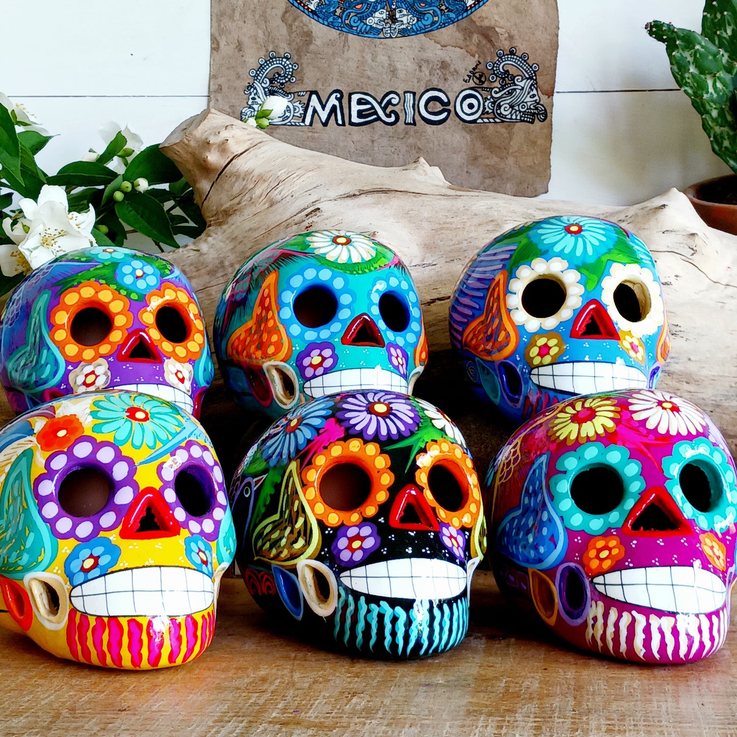 Colorful sugar skull decorations on a wooden surface with 'Mexico' text in the background.
