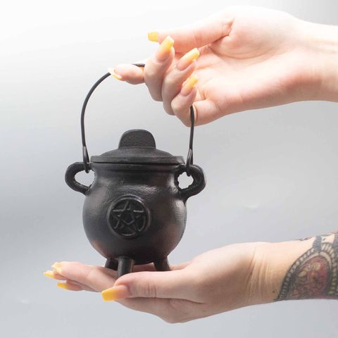 Within the sacred grove of time, the cauldron has always held the breath of transformation. This Cast Iron Cauldron with Pentagram (6.5x13cm) is not merely a vessel—it is an ancient conduit through which intention meets the Elemental realms.
Forged from enduring cast iron, this cauldron holds heat like the Earth holds memory. Small enough to rest upon your altar, yet powerful enough to summon change, it is ideal for burning herbs, resins, or incense during your spellwork, rituals, and sacred rites. The pen