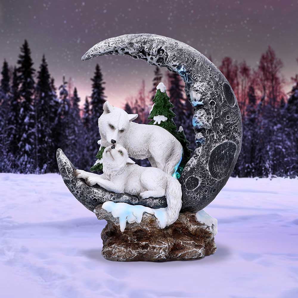 Decorative sculpture of two wolves on a moon-shaped platform with a snowy landscape background.