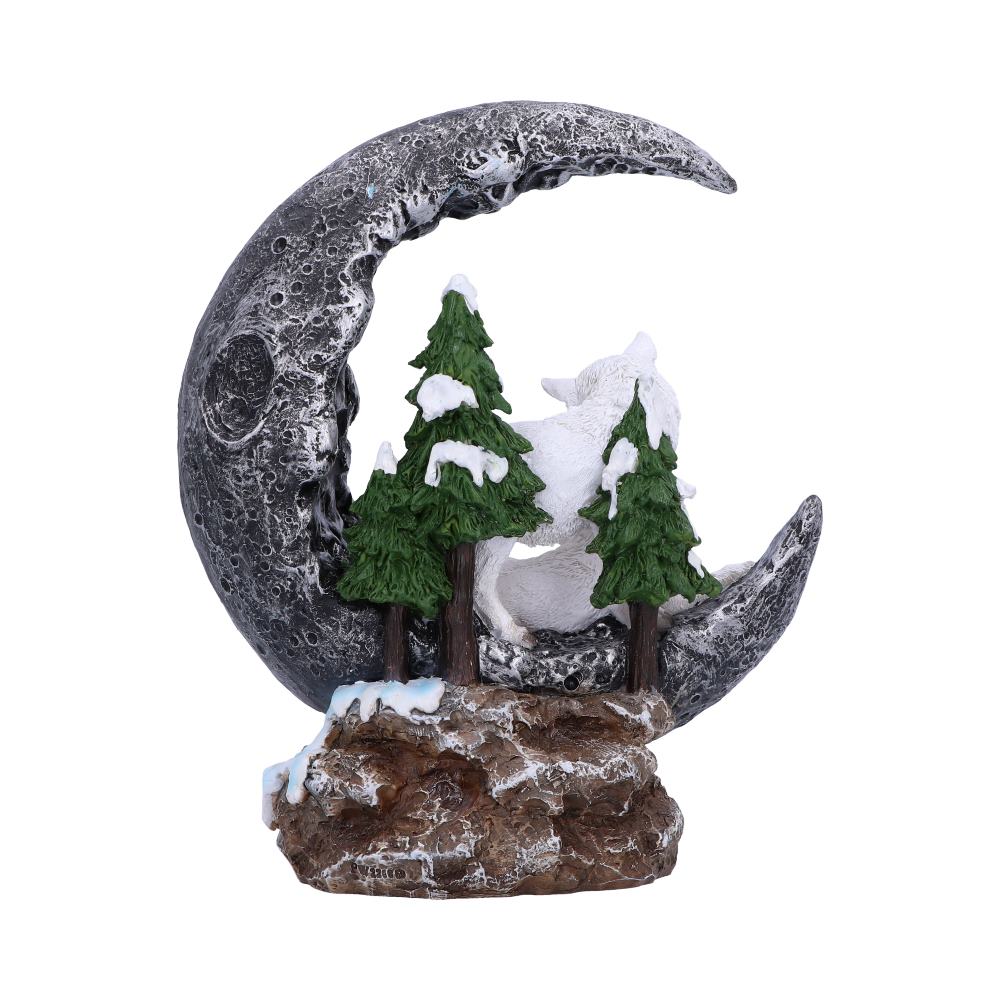 Decorative moon-shaped sculpture with trees and a snow-covered landscape on a white background