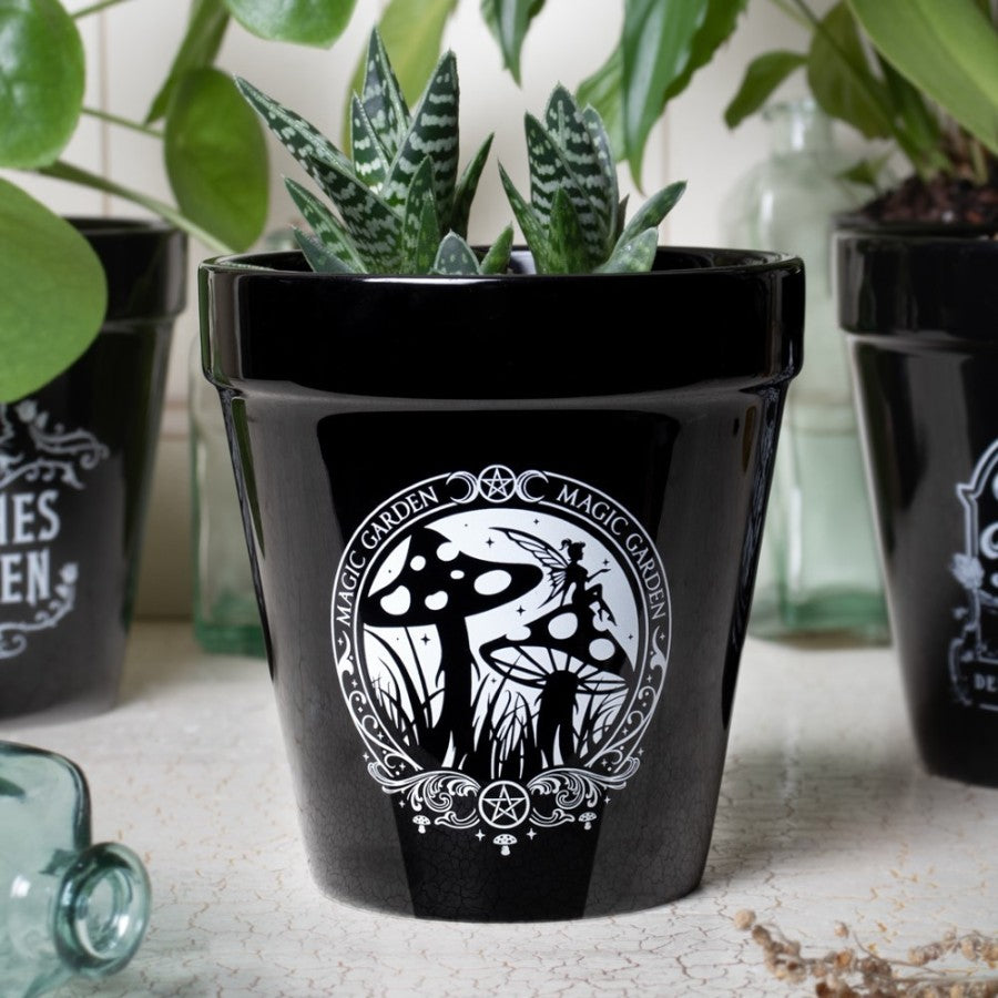 A Vessel of Verdant Arcana – by Alchemy Gothic
Summon nature’s magic with this spellbinding ceramic plant pot by Alchemy Gothic. Featuring their captivating Magic Garden artwork—where fae spirits dance among toadstools and otherworldly flora—this pot is a sacred tool for the witch, the alchemist, or the dark apothecary.
Use it to cradle herbs, gothic blooms, or botanical spells. Whether displayed in your apothecary, sacred altar, or shadowed garden, this vessel will flourish with intention.
Crafted from d