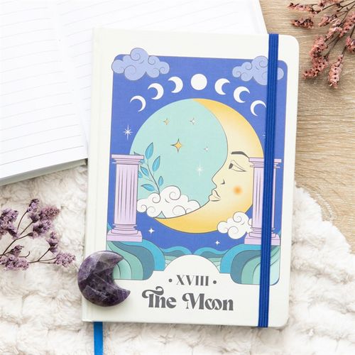 Notebook with celestial design featuring a moon and stars on a decorative surface.