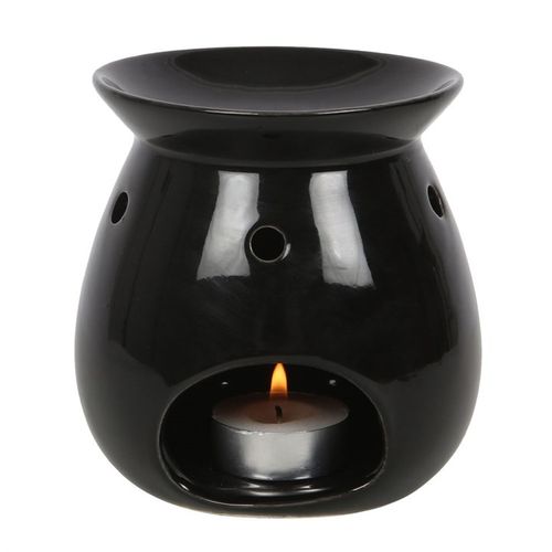 Black ceramic oil burner with a lit candle inside on a white background