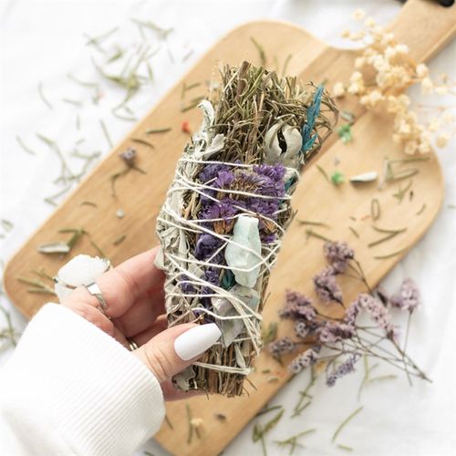 The act of ‘smudging’ is a traditional Native American practice used to cleanse and purify spaces using the smoke of burning sacred herbs. Sustainably sourced and made in the USA, this beautiful ritual wand features fragrant rosemary, white sage, lavender flowers, abalone shell pieces and a raw aventurine crystal thoughtfully handtied into a tight bundle for burning and display.