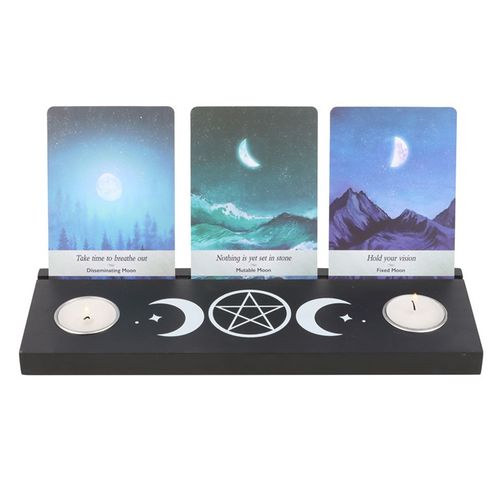 Display tarot card readings with this black wooden triple moon tarot card stand, complete with two spaces for holding tealight candles to create ambiance and allow the meaning of the cards to resonate. Whether it's used for displaying treasured tarot cards for their meaning or their unique design, this piece will add mystical allure to any home.