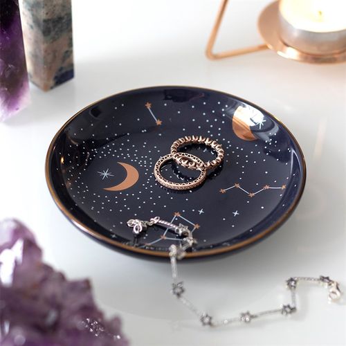 Jewelry tray with celestial design on a white surface with crystals and candles.