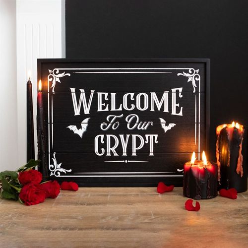 Transform any shadowy space into a snug gothic retreat with this enchanting plaque featuring the words 'Welcome to Our Crypt' surrounded by fluttering bats. Equipped with sawtooth hooks for easy hanging or perfect for leaning against a wall, it brings an instant mystical charm to your crypt. Measures 30cm high, 40cm wide, and 1.6cm deep.