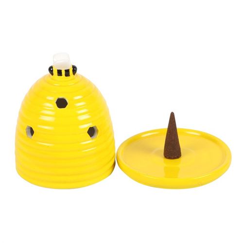Yellow ceramic beehive-shaped container with a brown cone on a white background