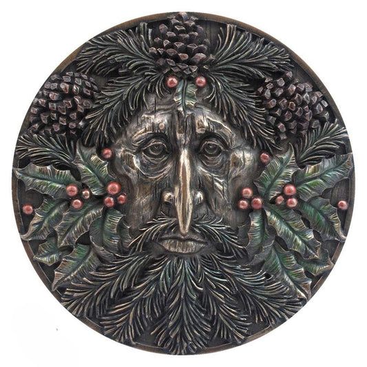 Decorative plaque with a face surrounded by foliage and berries on a white background