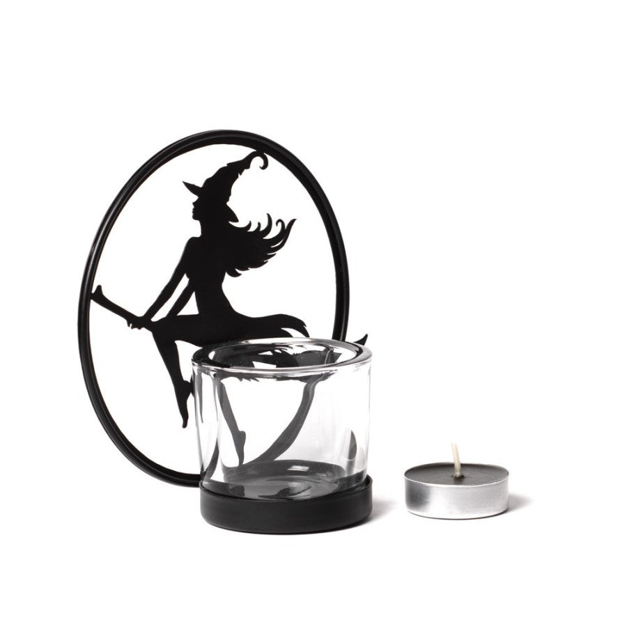 Illuminate your sacred space with the Witch by Moonlight Tealight Holder by Alchemy Gothic. Handcrafted from black-coated iron and shimmering glass, this mystical creation captures the silhouette of a witch soaring across a radiant full moon. As candlelight dances through the glass, it awakens the essence of freedom, transformation, and divine feminine power—a luminous reminder of your own inner witch rising under lunar light.
Perfect for altar adornment, ritual ambience, or as a centrepiece for moon cerem
