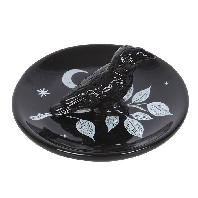 Black decorative plate with white designs on a white background