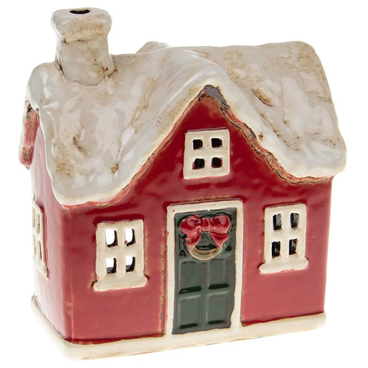 From the Village Pottery workshop comes this hand-crafted Christmas Traditional House tealight holder, made with care and timeless charm. Shaped in ceramic and finished with rustic detailing, it captures the magic of a snow-covered village scene. Measuring 12cm x 13cm x 9cm, this tealight house glows beautifully when a candle is placed inside, lighting up the windows with a cosy festive warmth. Perfect for mantelpieces, table settings, or as part of a winter village display, this ceramic tealight house is a