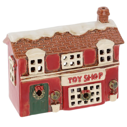 Crafted in the Village Pottery workshop, this Christmas Toy Shop tealight holder brings the magic of a festive village scene to life. Handmade from ceramic with charming details, it captures the nostalgic feel of an old-world toy shop glowing on a snowy winter’s evening. Measuring 12 x 15.5 x 6.5cm, it creates a warm, cosy atmosphere when lit with a tealight candle. Perfect for mantelpieces, window ledges, or as part of a Christmas village display, this ceramic tealight house is both decorative and function
