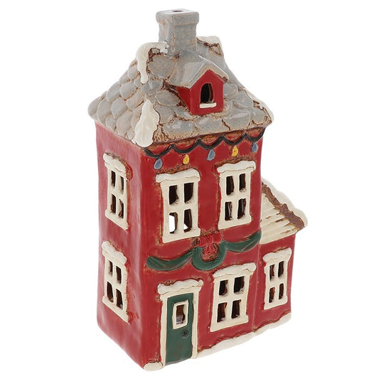 From the Village Pottery collection, this Christmas Wreath House tealight holder is a handcrafted ceramic piece that captures the warmth and charm of festive tradition. Decorated with a classic wreath and rustic detailing, it evokes the cosy spirit of a snowy winter’s evening. Measuring 27 x 15.5 x 9cm, this larger tealight house makes a striking addition to mantelpieces, shelves, or Christmas village displays. When lit with a candle, the windows glow to create a welcoming, homely atmosphere. A timeless kee