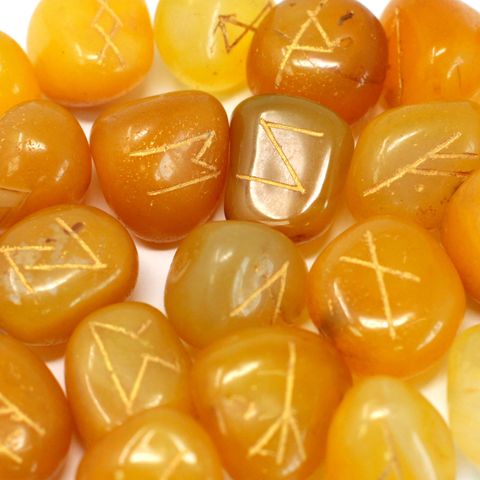 Unlock the secrets of the runes with this Yellow Onyx Rune Set in Pouch, a stunning 25-piece collection hand-carved from natural semi-precious stone. Each set includes 24 stones engraved with ancient rune symbols and one blank stone, all housed in a soft velvet pouch for safekeeping.

Yellow Onyx is a powerful stone known for promoting mental clarity, emotional balance, and inner strength. It helps dispel negative energy, boosts confidence, and supports wise decision-making—making it the perfect companion f