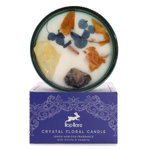 Enter a realm of enchantment with the Hop Hare Crystal Magic Flower Candle - The Sun, infused with Citrine and Sodalite gemstones and adorned with delicate dried flowers. Each candle includes a tarot card revealing a mystical tale, wrapped in the luminous scent of Lemon Horizon. Experience the transformative power and botanical charm through notes of lemongrass, mandarin, honeysuckle, and white musk. With a burn time of 22 hours, this candle invites you to bask in its magical glow.

Each candle tells its ow