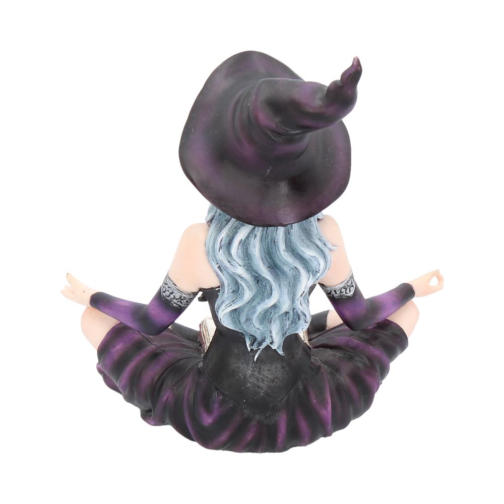 Figurine of a witch with purple and black outfit and hat on a white background