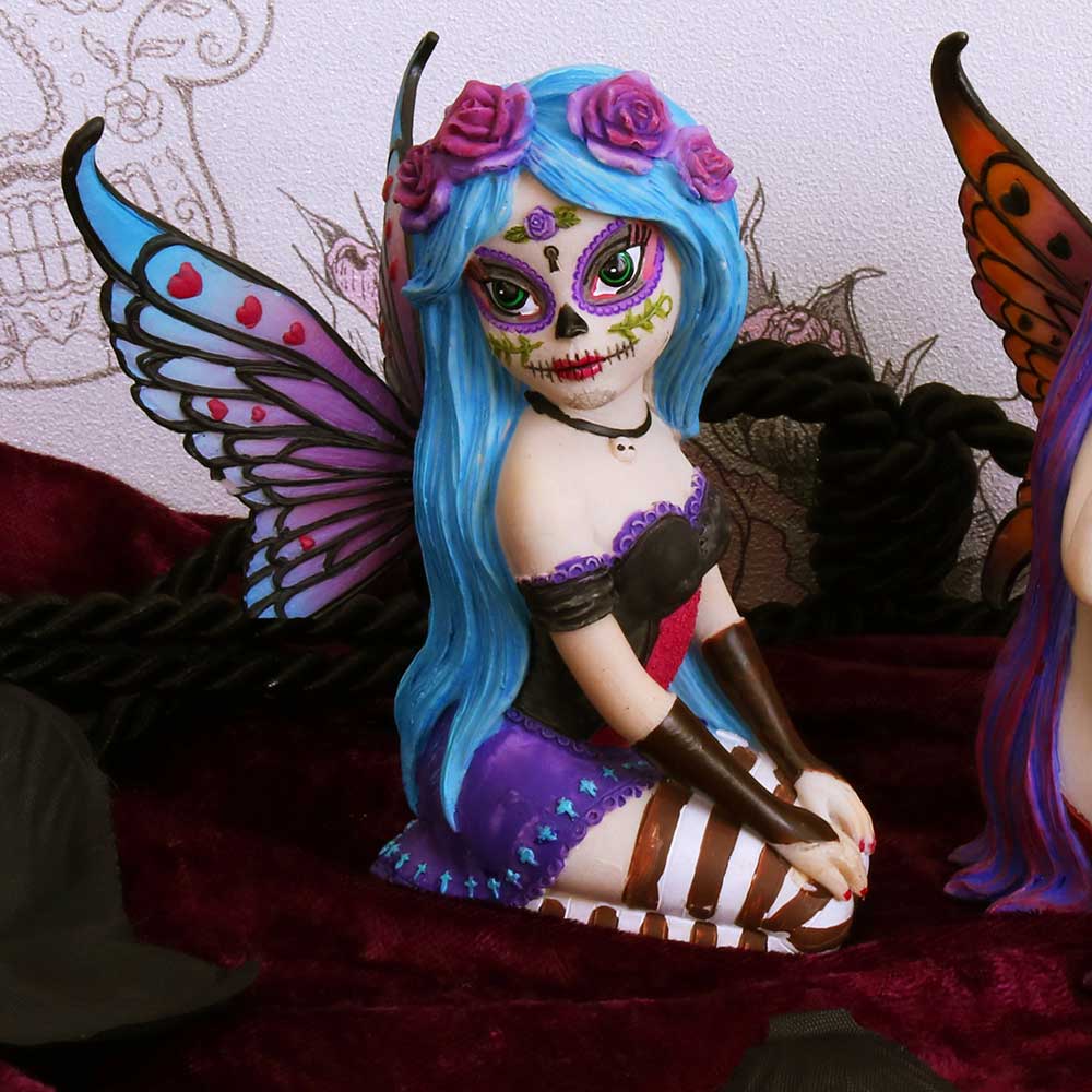 Colorful figurine with butterfly wings and blue hair on a red surface