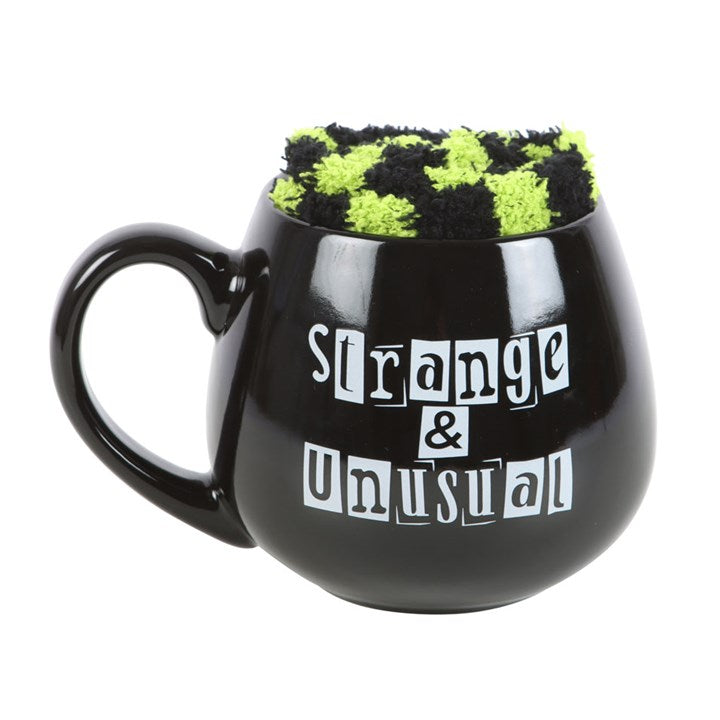 Forget wearing your heart on your sleeve — say it like it is with the Strange and Unusual Mug & Stripey Socks Gift Set, designed for those who proudly embrace their quirks and curiosities.

This bold 500ml ceramic mug features the iconic gothic phrase “Strange and Unusual”, a declaration of individuality for those who walk their own path. Paired with cosy black and white stripey socks, it’s the ultimate comfort combo for sipping, lounging, and celebrating your weird and wonderful self.

Both microwave and d