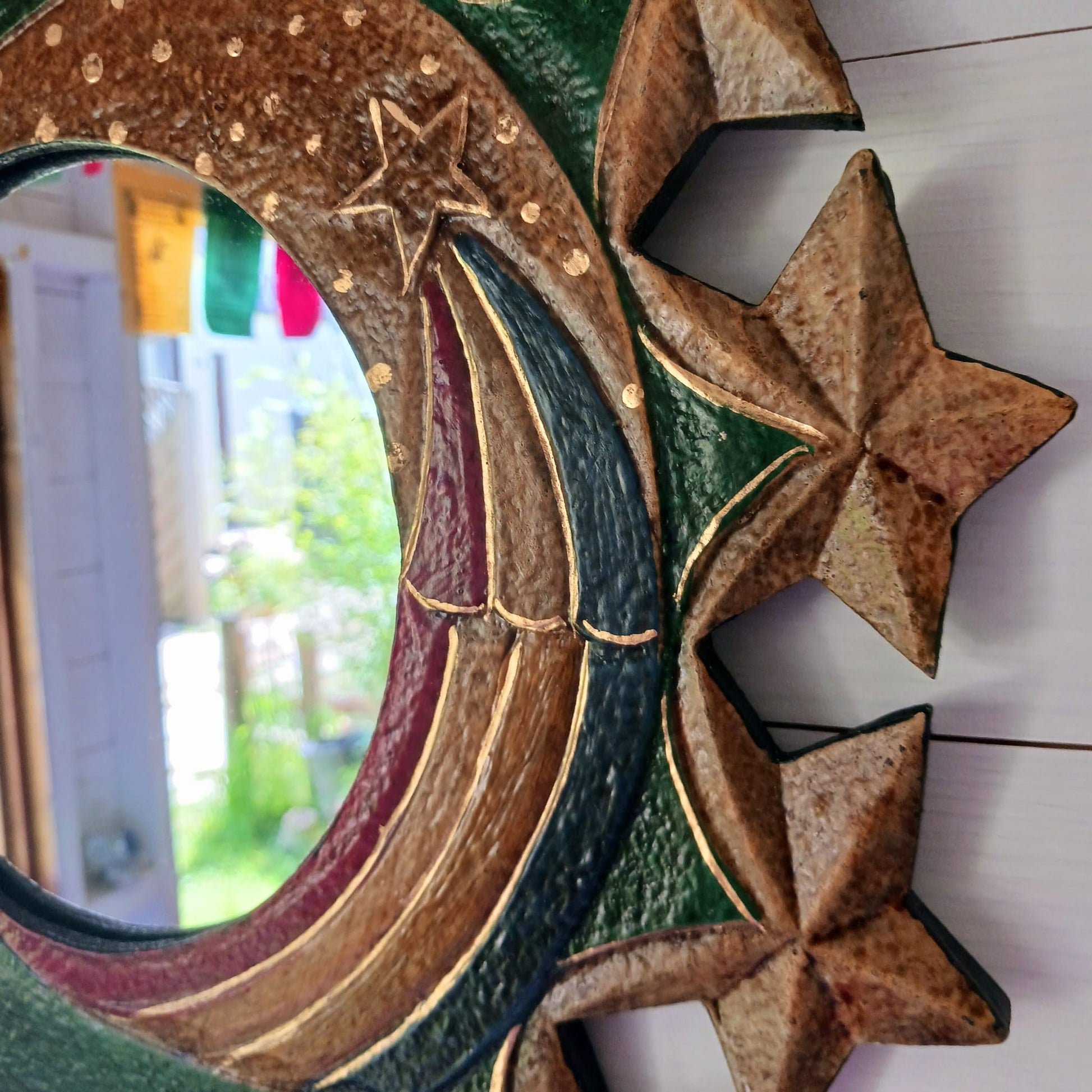 These Celestial Moon and Stars Mirrors are handcrafted and painted in Indonesia. The distinctive sun, moon, and star motifs create a unique aesthetic, while the hoop on the reverse provides easy and secure hanging. Each mirror also has slight variations in color due to the handmade nature of the item, making every piece one of a kind. 
