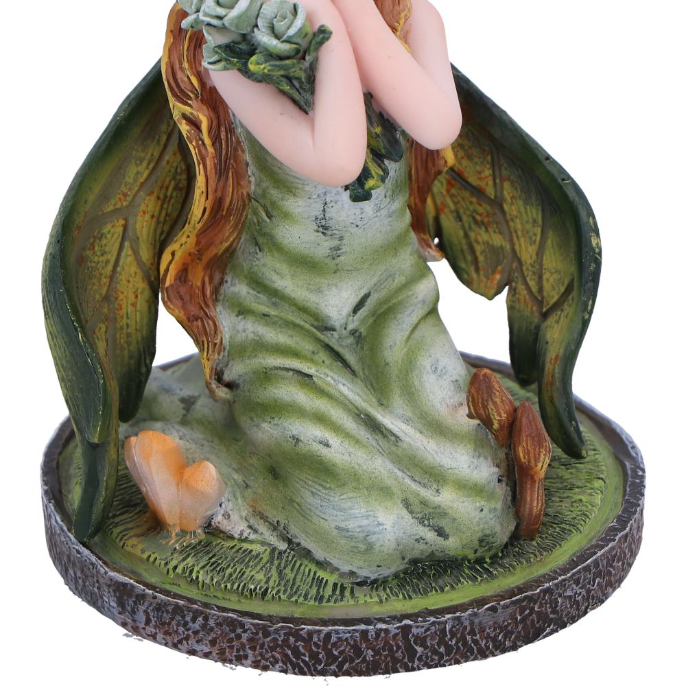 Fairy figurine with green dress and leafy wings on a white background