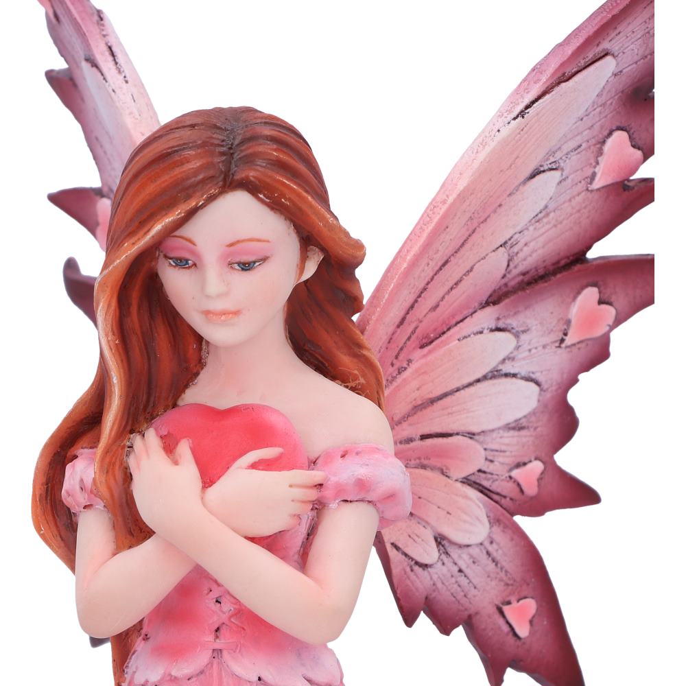 Fairy figurine with pink wings and a heart, on a white background