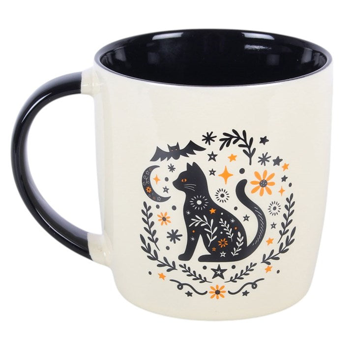Enjoy a warm drink in seasonal style with this ceramic mug, featuring a folk-inspired black cat design with simple floral and nature details. Perfect for autumn days at home, it makes a thoughtful gift for anyone who enjoys themed kitchenware and cosy moments. Ideal for tea, coffee, or hot chocolate. Microwave safe. Dishwasher safe.