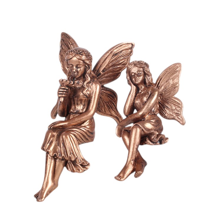 Give shelves and ledges a playful woodland companion with this set of two resin fairy shelf sitters, each finished in an antique bronze effect with delicately sculpted wings and flowing dresses. Their dangling legs make them ideal for bookcases, mantelpieces and bedside displays, while the matching pair makes a thoughtful fairycore gift.
