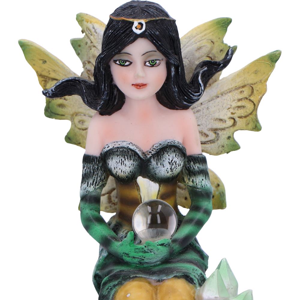 Fairy figurine with green wings and a crystal ball on a white background
