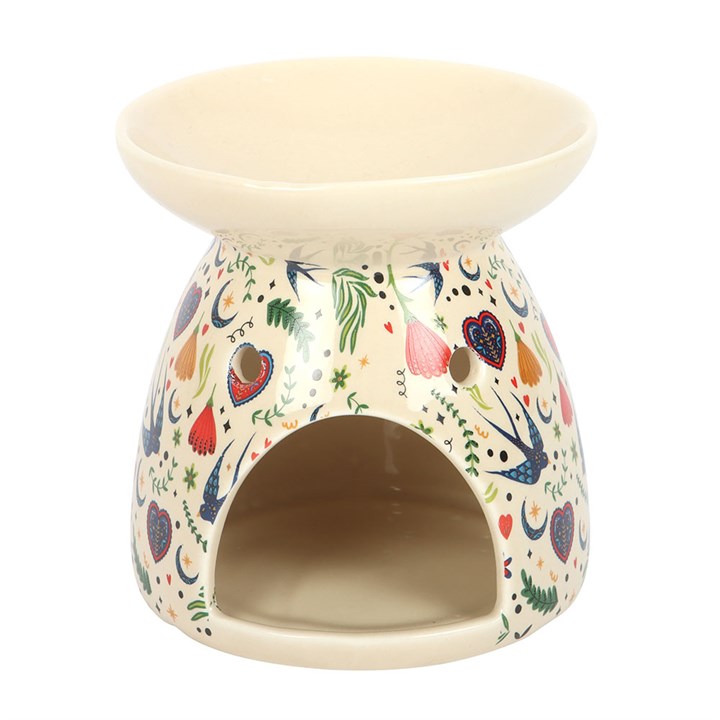 This cream ceramic oil burner features a delicate Midnight Bloom folk floral design, making it both a practical and decorative addition to any room. Simply place a single standard tealight in the space at the back and add a few drops of diluted fragrance oil or wax melts in the bowl. Suitable for use with both wax and fragrance oil. Never leave a lit candle unattended.
