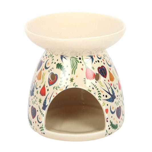 This cream ceramic oil burner features a delicate Midnight Bloom folk floral design, making it both a practical and decorative addition to any room. Simply place a single standard tealight in the space at the back and add a few drops of diluted fragrance oil or wax melts in the bowl. Suitable for use with both wax and fragrance oil. Never leave a lit candle unattended.