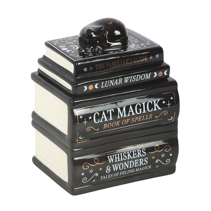 Add a touch of mystical style to the home with this striking book stack oil burner, topped with a resting black cat and detailed with magical titles. Perfect for creating a relaxing atmosphere while enjoying favourite fragrances, it makes a unique gift for cat lovers and fans of witchy home accessories. Always remove the lid whilst in use. Recommended for use with fragrance oil diluted with water.