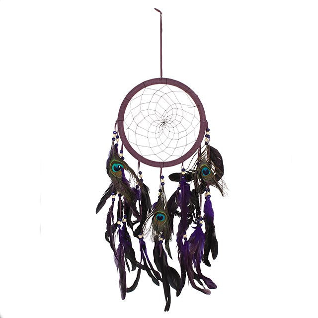 In the old ways of the Ojibwe people, the dreamcatcher was woven as a sacred guardian. Hung above the place of rest, it allows good dreams to flow like water through its web, while the ill-spirited dreams are caught and dissolved with the first light of day.

This Purple Peacock Feather Dreamcatcher carries the medicine of color and spirit. Purple, long honored as the color of vision and higher wisdom, calls upon the unseen realms and awakens the spirit to deeper truths. The peacock feather, with its radian