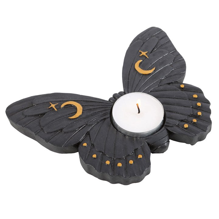 Illuminate your space with this enchanting tealight holder. Made of resin, this sleek tealight holder features a moth design complete with intricate details and a deep black finish. The design is complemented by gold crescent moon and stars accents, adding celestial charm to decor. Accommodates a standard single tealight for casting captivating shadows and creating a mesmerizing ambiance. Ideal for enhancing both modern and eclectic interior spaces. Remember to never leave a burning candle unattended. Do no