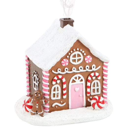 Step into an enchanted Christmas tale with this charming pink gingerbread house incense cone burner, adorned with delightful candy cane and sugar frosting accents. Light a cone inside, and watch as mystical smoke curls from the chimney, casting a spell of festive wonder. When unlit, it transforms into a captivating ornament, destined to be a cherished part of your holiday altar for many seasons to come