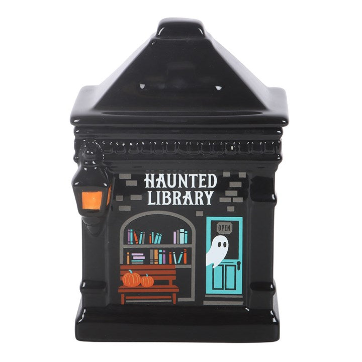 Celebrate the magic of a ghost story with this detailed ceramic oil burner shaped like a classic haunted library. Its whimsical design features tiny book details and glowing windows, making it a must-have for book lovers seeking accessories to create a cute but spooky book nook in the home. Always remove the lid whilst in use. Recommended for use with fragrance oil diluted with water.