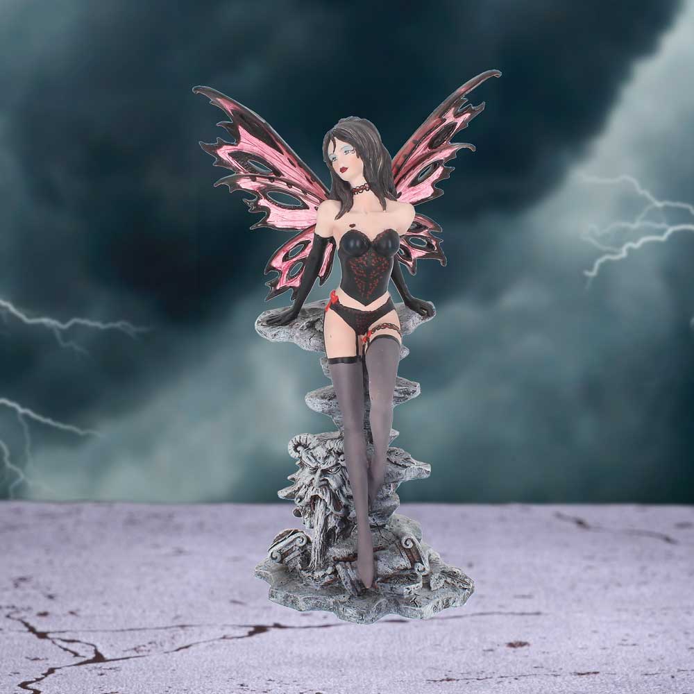 Fairy figurine with pink wings against a stormy sky